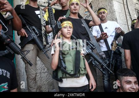 Naplouse, Palestine. 24 juillet 2024. Des hommes armés portent leurs armes lors des funérailles du palestinien Abdel Nasser Sarhan, âgé de 25 ans, dans le camp de réfugiés de Balata, à l'est de la ville de Naplouse, en Cisjordanie occupée. Abdel Nasser Sarhan a été abattu par les forces israéliennes alors qu'il était au sommet de son travail en tant qu'officier dans les douanes palestiniennes. Crédit : SOPA images Limited/Alamy Live News Banque D'Images