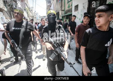 Naplouse, Palestine. 24 juillet 2024. Des hommes armés portent leurs armes lors des funérailles du palestinien Abdel Nasser Sarhan, âgé de 25 ans, dans le camp de réfugiés de Balata, à l'est de la ville de Naplouse, en Cisjordanie occupée. Abdel Nasser Sarhan a été abattu par les forces israéliennes alors qu'il était au sommet de son travail en tant qu'officier dans les douanes palestiniennes. Crédit : SOPA images Limited/Alamy Live News Banque D'Images