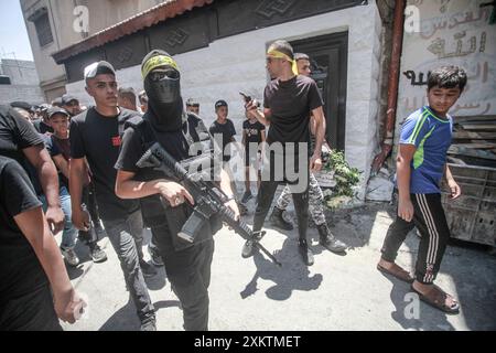 Naplouse, Palestine. 24 juillet 2024. Des hommes armés portent leurs armes lors des funérailles du palestinien Abdel Nasser Sarhan, âgé de 25 ans, dans le camp de réfugiés de Balata, à l'est de la ville de Naplouse, en Cisjordanie occupée. Abdel Nasser Sarhan a été abattu par les forces israéliennes alors qu'il était au sommet de son travail en tant qu'officier dans les douanes palestiniennes. Crédit : SOPA images Limited/Alamy Live News Banque D'Images