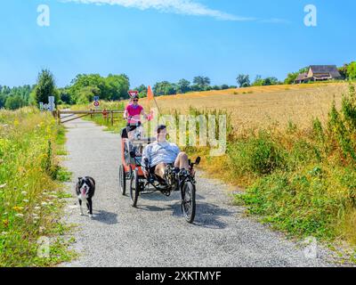 Couple avec chien à vélo le long de la voie verte - homme sur vélo couché - Bossay-sur-Claise, Indre-et-Loire (37), France. Banque D'Images