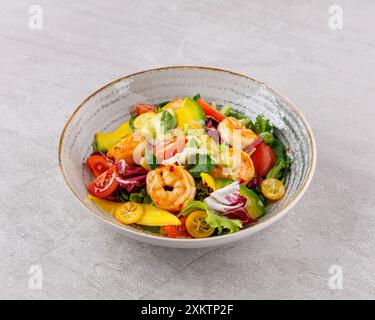 Salade aux crevettes en sauce aigre-douce avec mangue et avocat. sur fond gris Banque D'Images