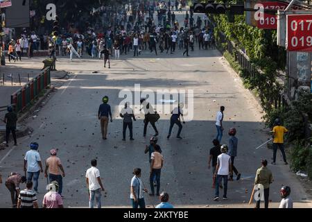 Des manifestants anti-quotas affrontent des membres de la Bangladesh Chhatra League (BCL) (aile étudiante du parti au pouvoir), dans la zone du collège de Dhaka. De violents affrontements entre groupes étudiants rivaux à propos des quotas pour les emplois gouvernementaux, a déclaré la police. Cela s'est produit un jour après que plus de 1500 personnes ont été blessées. Banque D'Images