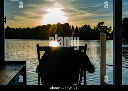 05.07.2024 Heidesee Im Foto : ein Mann sitzt in einem Liegestuhl auf einem Hausboot auf einem See Heidesee Brandenburg *** 05 07 2024 Heidesee sur la photo un homme est assis dans une chaise longue sur une péniche sur un lac Heidesee Brandenburg Copyright : xx 240705 hausboot-urlaub-brandenburg 1 Banque D'Images