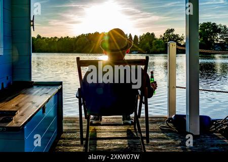 05.07.2024 Heidesee Im Foto : ein Mann sitzt mit einer Flasche Bier in einem Liegestuhl auf einem Hausboot auf einem See Heidesee Brandenburg *** 05 07 2024 Heidesee sur la photo un homme est assis avec une bouteille de bière dans une chaise longue sur une péniche sur un lac Heidesee Brandenburg Copyright : xx 240705 hausboot-urlaub-brandenburg 2 Banque D'Images