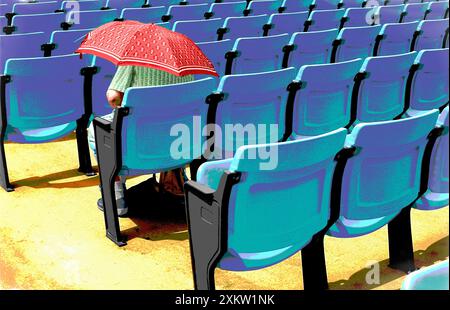 Une main peinte je photographie une femme âgée assise seule dans un auditorium extérieur tenant un parapluie comme protection contre le soleil Banque D'Images