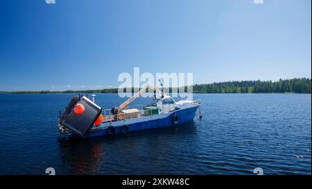 Petit chalutier finlandais de pêche lacustre ancré derrière le brise-lames du lac Pohjois-Konnevesi , Finlande Banque D'Images
