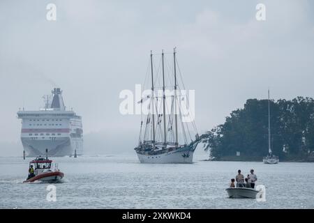 MARIEHAMN, Åland, FINLANDE - 24 JUILLET 2024 : le grand voilier Kapitan Borchardt se met de côté pour le ferry de croisière Baltic Princess qui passe dans le port. Premier jour des trois jours Åland Stage de la course de grands voiliers 2024 dans le port principal, Mariehamn, Åland, Finlande. Photo : Rob Watkins/Alamy Live News. INFO : la Tall Ships Race est un événement annuel de voile mettant en vedette des grands voiliers historiques et modernes. Il promeut l'amitié internationale et la formation des jeunes, attirant des participants et des spectateurs du monde entier pour célébrer le patrimoine maritime et l'art de la voile traditionnelle. Banque D'Images