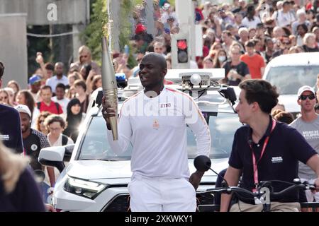 Paris, France. 24 juillet 2024. Un porteur de la torche porte la torche olympique à son arrivée à l’Archiveau de la Défense dans l’arène de la Défense à Paris, France, le mercredi 24 juillet 2024. La cérémonie d'ouverture a lieu le 26 juillet, 100 ans après la dernière fois que Paris a accueilli les jeux. Photo de Richard Ellis/UPI crédit : UPI/Alamy Live News Banque D'Images