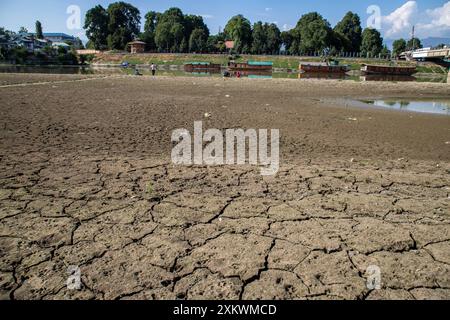 24 juillet 2024, Srinagar, Jammu-et-Cachemire, Inde : une portion asséchée de la rivière Jhelum est vue suite à la sécheresse continue à Srinagar, la capitale de la région himalayenne du Cachemire. Le Jammu-et-Cachemire est confronté à une hausse sans précédent des températures et des conditions météorologiques sèches. Ce changement climatique affecte non seulement l'écosystème de la région, mais aussi la vie de ses habitants. La région a connu une baisse significative des précipitations, certaines zones recevant moins de 50 % de leurs précipitations annuelles moyennes. Les experts mettent en garde contre les impacts négatifs sur les plans d'eau, les glaciers et k Banque D'Images