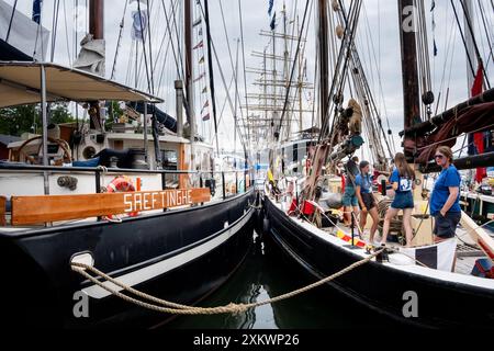 MARIEHAMN, Åland, FINLANDE - 24 JUILLET 2024 : de jeunes volontaires travaillent à bord d'un grand voilier amarré dans le port. Premier jour des trois jours Åland Stage de la course de grands voiliers 2024 dans le port principal, Mariehamn, Åland, Finlande. Photo : Rob Watkins/Alamy Live News. INFO : la Tall Ships Race est un événement annuel de voile mettant en vedette des grands voiliers historiques et modernes. Il promeut l'amitié internationale et la formation des jeunes, attirant des participants et des spectateurs du monde entier pour célébrer le patrimoine maritime et l'art de la voile traditionnelle. Banque D'Images