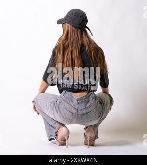 streetstyle casquette cheveux foncés décontracté éraflures gris look ajusté casquette camionneur débardeur style femme posing Banque D'Images