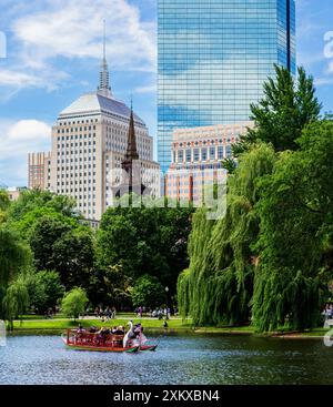 Boston, Massachusetts, États-Unis - 18 juin 2022 : étang du jardin public de Boston avec un bateau à cygne et des bâtiments de Back Bay en arrière-plan. Banque D'Images
