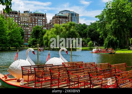 Boston, Massachusetts, États-Unis - 18 juin 2022 : étang du jardin public de Boston avec des bateaux cygnes et des bâtiments de Back Bay en arrière-plan. Banque D'Images