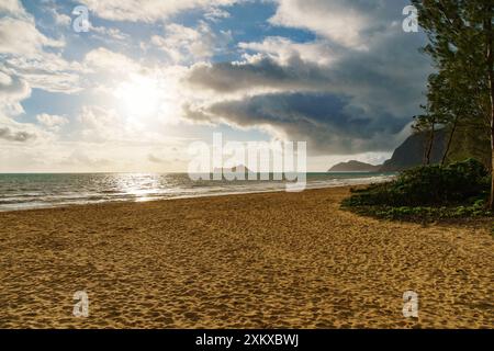 Le soleil brille à travers les nuages sur la plage, créant une belle scène Banque D'Images