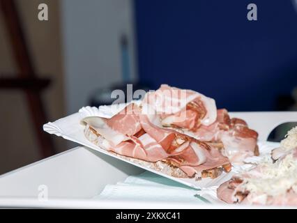 Tranches de prosciutto italien sur pain blanc, un apéritif savoureux et élégant, parfait pour toute occasion spéciale, un concept artistique culinaire Banque D'Images