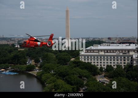 Un hélicoptère Washington MH-65 Dolphin de la station de la Garde côtière américaine vole le long du Washington Monument lors d'un exercice de formation avec un autre équipage MH-65 Dolphin à Washington D.C. le 18 juillet 2024. Les équipages ont effectué une formation sur une trajectoire de vol à travers Washington D.C. (photo de la Garde côtière américaine par le maître de 3e classe Christopher Bokum) Banque D'Images