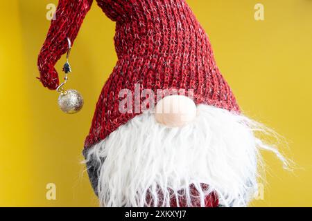 Mignon elfe avec la barbe et un chapeau rouge sur un fond jaune Banque D'Images