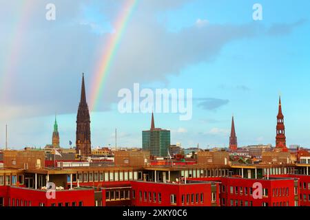 Rainbow est vu au-dessus d'une ville avec de grands bâtiments. Horizon urbain de Hambourg avec un arc-en-ciel vibrant au-dessus de la tête Banque D'Images