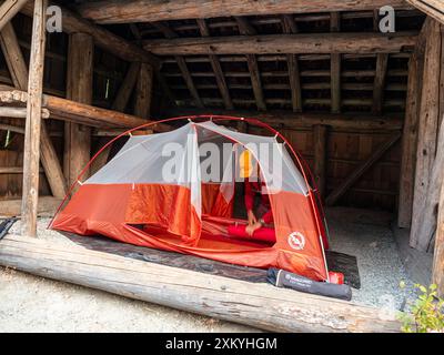 WA25562-00...WASHINGTON - faire ses bagages après une nuit a évité les cendres du feu de forêt dans un abri à High Bridge Camp, dans la zone de loisirs nationale du lac Chelan. Banque D'Images
