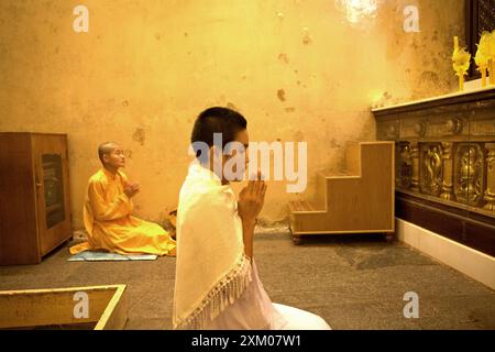 Bhikkhuni (religieuses bouddhistes) priant à l'intérieur de la chambre sainte où la statue du Bouddha d'or est située au temple Mahabodhi à Bodh Gaya, Bihar, Inde. Banque D'Images