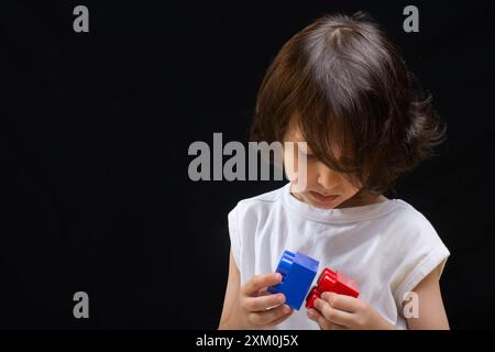 Les mains des enfants jouer avec des blocs colorés les blocs de lego Banque D'Images