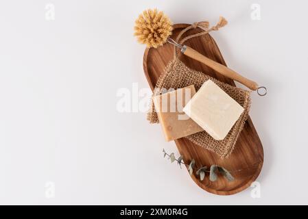 Barres de savon bio, gant de toilette et brosse en bambou sur plateau en bois, vue de dessus. Concept de nettoyage. Banque D'Images