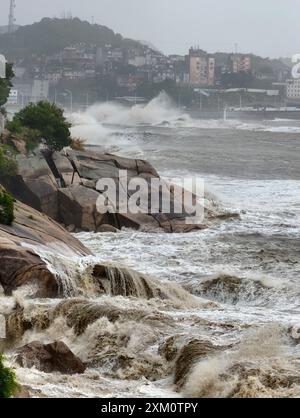 (240725) -- NINGDE, 25 juillet 2024 (Xinhua) -- D'énormes vagues battent le rivage dans le canton de Sansha du comté de Xiapu, dans la province du Fujian du sud-est de la Chine, 25 juillet 2024. La province du Fujian, dans l'est de la Chine, avait relocalisé 156 800 résidents à 7 heures jeudi à l'approche du typhon Gaemi, le troisième typhon de cette année, ont déclaré les autorités locales. Entre-temps, 73 traversées de traversiers le long de la côte de la province ont été suspendues et 97 vols ont été annulés. Plus de 29 000 personnes travaillant sur des radeaux de pêche le long de sa côte ont été évacuées vers le rivage, et 733 bateaux de pêche ont trouvé refuge dans les ports et quelque 3 200 peo Banque D'Images