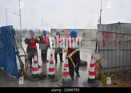 (240725) -- NINGDE, 25 juillet 2024 (Xinhua) -- des membres du personnel d'urgence sont en garde contre le typhon Gaemi dans un port du canton de Sansha dans le comté de Xiapu, province du Fujian, au sud-est de la Chine, le 25 juillet 2024. La province du Fujian, dans l'est de la Chine, avait relocalisé 156 800 résidents à 7 heures jeudi à l'approche du typhon Gaemi, le troisième typhon de cette année, ont déclaré les autorités locales. Entre-temps, 73 traversées de traversiers le long de la côte de la province ont été suspendues et 97 vols ont été annulés. Plus de 29 000 personnes travaillant sur des radeaux de pêche le long de sa côte ont été évacuées vers le rivage, et 733 bateaux de pêche HAV Banque D'Images