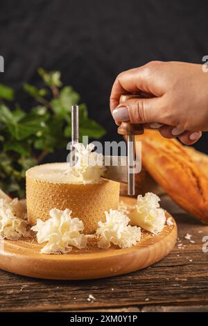 Femme tranchant du fromage avec girolle sur une table en bois rustique Banque D'Images