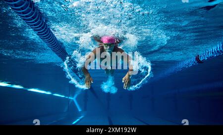 Nageur compétitif, homme au physique athlétique capturé sous l'eau lors d'une séance d'entraînement intense sous l'eau dans une piscine propre. Banque D'Images