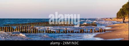 Mielno, Pologne - juin 2022 : coucher de soleil sur la mer Baltique. Vue sur l'ancien brise-lames en bois et son reflet dans l'eau. Poméranie occidentale. est E Banque D'Images