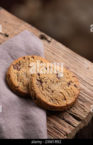 Biscuits aux pépites de chocolat fraîchement cuits. Fond en bois. Banque D'Images