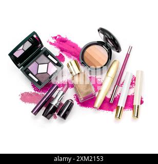 Vue de dessus de la collection de maquillage contre fond coloré peint abstrait. Eyeliner, rouge à lèvres, poudre de maquillage, ombre à paupières Banque D'Images