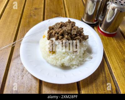 Riz avec de la viande rôtie et des pois chiches sur une table en bois Banque D'Images