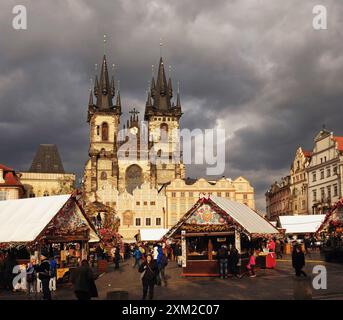 Prague, place de la vieille ville, pâques avec des cabanes de festival décorées traditionnellement dans le. Soleil brille sur l'église notre-Dame avant Týn, et nuages sombres d'orage Banque D'Images