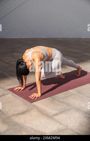 Une femme brune vêtue de vêtements de sport dans une pose de yoga Banque D'Images