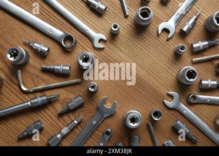 Différents outils de mécanicien automatique sur la table en bois, pose à plat. Espace pour le texte Banque D'Images