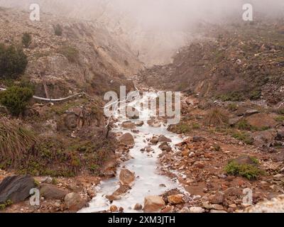 Un paysage rocheux et aride avec un petit jet d'eau qui le traverse. L'eau est claire et froide, et les roches sont dispersées dans l'ARE Banque D'Images