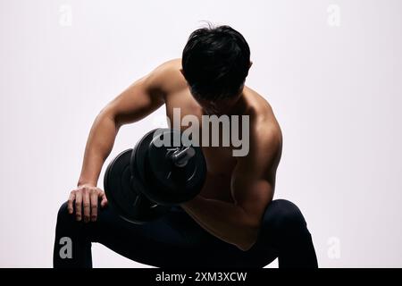 Homme asiatique soulevant Une haltère Banque D'Images