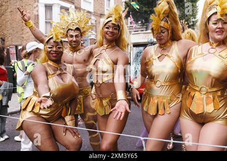 Carnaval de Notting Hill à Londres, Royaume-Uni : un groupe d'artistes de carnaval en costumes dorés dans la rue Banque D'Images