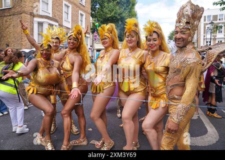 Carnaval de Notting Hill à Londres, Royaume-Uni : un groupe d'artistes de carnaval en costumes dorés dans la rue Banque D'Images