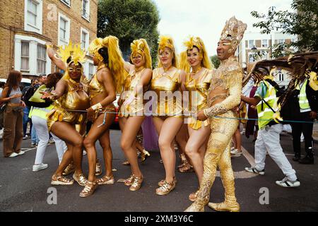 Carnaval de Notting Hill à Londres, Royaume-Uni : un groupe d'artistes de carnaval en costumes dorés dans la rue Banque D'Images