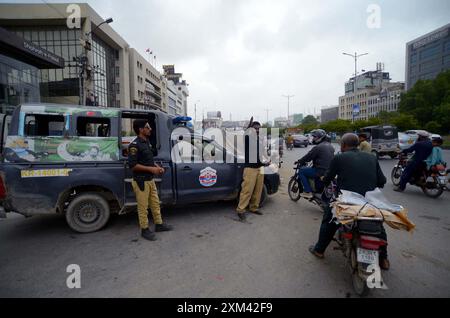 Les navetteurs ont vu inquiets et confrontés à des problèmes en raison de la fermeture de la route lors de l'opération de réutilisation après un accident de la circulation mortel, au pont de colonie Baloch à Karachi le jeudi 25 juillet 2024. Une voiture a été écrasée sous un pétrolier près du pont de colonie Baloch à Karachi, provoquant un embouteillage majeur et soulevant des inquiétudes quant à un risque potentiel d'incendie. Le conducteur du pétrolier a fui les lieux après l'accident. Le pétrolier a commencé à fuir de l'essence, causant une perturbation significative de la circulation. Les responsables des secours ont demandé de la machinerie lourde pour soulever le pétrolier et libérer la voiture. Banque D'Images