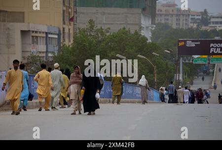 Les navetteurs ont vu inquiets et confrontés à des problèmes en raison de la fermeture de la route lors de l'opération de réutilisation après un accident de la circulation mortel, au pont de colonie Baloch à Karachi le jeudi 25 juillet 2024. Une voiture a été écrasée sous un pétrolier près du pont de colonie Baloch à Karachi, provoquant un embouteillage majeur et soulevant des inquiétudes quant à un risque potentiel d'incendie. Le conducteur du pétrolier a fui les lieux après l'accident. Le pétrolier a commencé à fuir de l'essence, causant une perturbation significative de la circulation. Les responsables des secours ont demandé de la machinerie lourde pour soulever le pétrolier et libérer la voiture. Banque D'Images