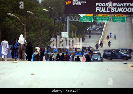 Les navetteurs ont vu inquiets et confrontés à des problèmes en raison de la fermeture de la route lors de l'opération de réutilisation après un accident de la circulation mortel, au pont de colonie Baloch à Karachi le jeudi 25 juillet 2024. Une voiture a été écrasée sous un pétrolier près du pont de colonie Baloch à Karachi, provoquant un embouteillage majeur et soulevant des inquiétudes quant à un risque potentiel d'incendie. Le conducteur du pétrolier a fui les lieux après l'accident. Le pétrolier a commencé à fuir de l'essence, causant une perturbation significative de la circulation. Les responsables des secours ont demandé de la machinerie lourde pour soulever le pétrolier et libérer la voiture. Banque D'Images