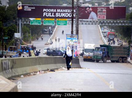 Les navetteurs ont vu inquiets et confrontés à des problèmes en raison de la fermeture de la route lors de l'opération de réutilisation après un accident de la circulation mortel, au pont de colonie Baloch à Karachi le jeudi 25 juillet 2024. Une voiture a été écrasée sous un pétrolier près du pont de colonie Baloch à Karachi, provoquant un embouteillage majeur et soulevant des inquiétudes quant à un risque potentiel d'incendie. Le conducteur du pétrolier a fui les lieux après l'accident. Le pétrolier a commencé à fuir de l'essence, causant une perturbation significative de la circulation. Les responsables des secours ont demandé de la machinerie lourde pour soulever le pétrolier et libérer la voiture. Banque D'Images