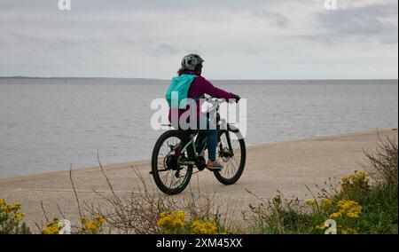 Une dame cycliste au bord de la mer Banque D'Images