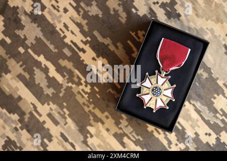 KIEV, UKRAINE - 10 JUILLET 2024 Médaille de la Légion du mérite américaine. Médaille de récompense militaire des États-Unis avec ruban et épingle. Accessoires de théâtre en papier faits à la main en gros plan Banque D'Images