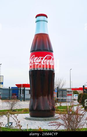 Vue de la bouteille de Coca Cola géante, grande, fausse et symbolique à l'entrée principale. À l'usine de soude CCI Coca Cola à Tachkent, Ouzbékistan. Banque D'Images