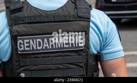 Gros plan de marquage « GENDARMERIE » écrit au dos d'un gilet pare-balles porté par un gendarme français. Notions de sécurité, de criminalité et de police en France Banque D'Images